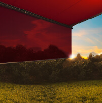 Zonbescherming met een rode zonnescherm en een zonsondergang op de achtergrond, groene tuin onderaan.
