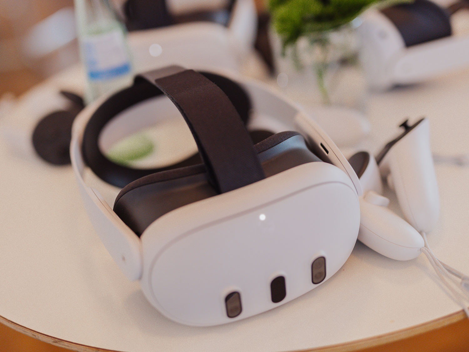 Een wit headset met een zwart bandje ligt op een ronde tafel.