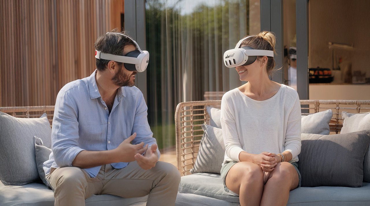 Twee mensen met virtual reality-brillen, zittend op een bank in een moderne omgeving.