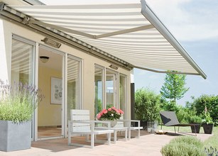 Terrassensituatie met een zonnige zonnescherm, plantenbakken en moderne meubels. 