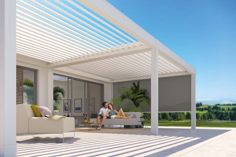 Terrassensituatie onder een moderne overkapping met schaduwdoeken en uitzicht op groene velden. Terrassensituatie onder een moderne overkapping met schaduwdoeken en uitzicht op groene velden.