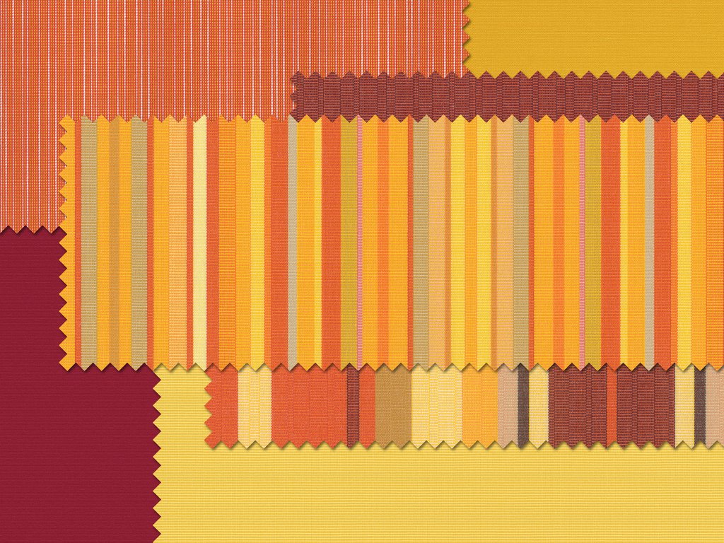 Textielstalen in warme kleuren zoals geel, oranje en paars met verschillende patronen en texturen.