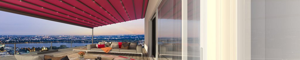 Een terras met een rode markies en een uitzicht op de stad, met een moderne zitgelegenheid en glazen schuifwanden.