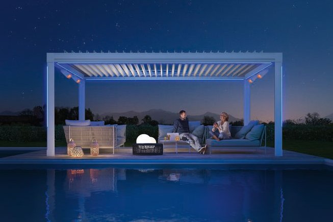 Terrassensituatie met overkapping, twee mensen zitten aan een zwembad onder een sterrenhemel.