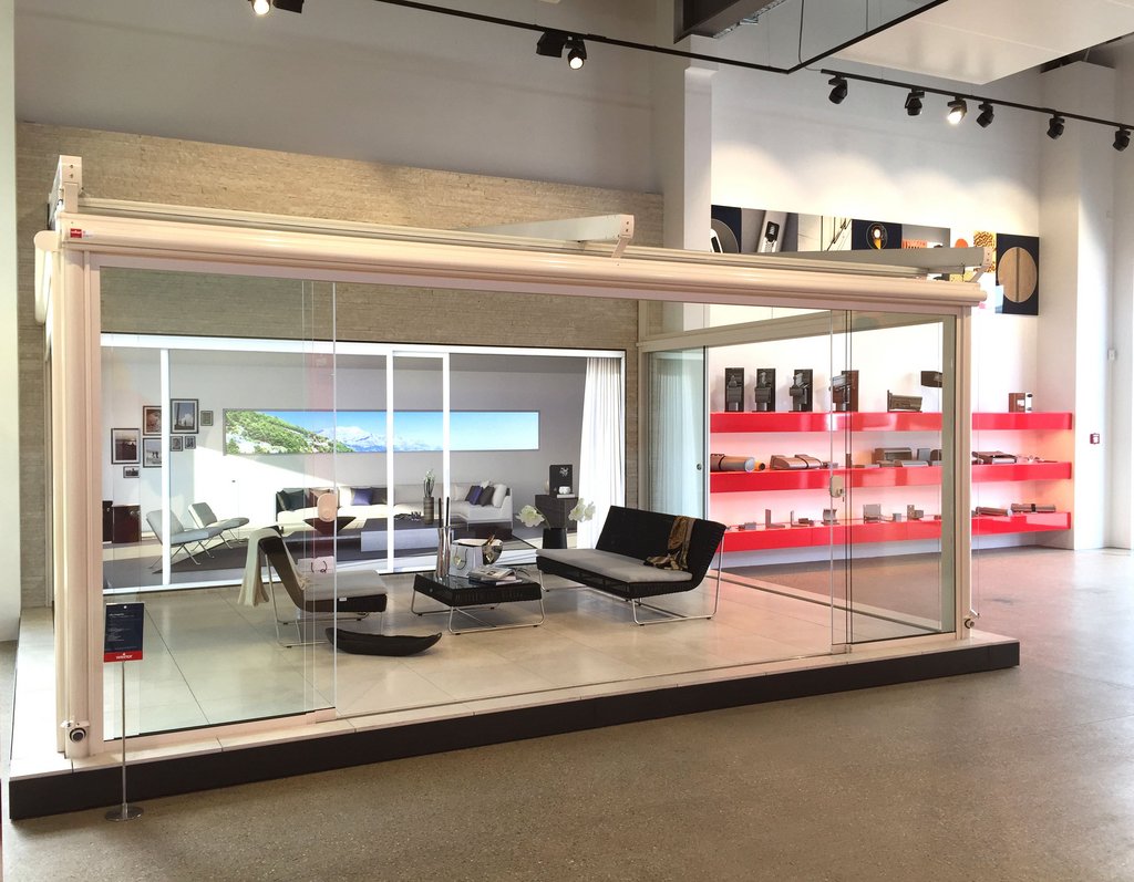 Moderne overkapping met glazen wanden in een showroom, afgewerkt in wit en zwart. Moderne overkapping met glazen wanden in een showroom, afgewerkt in wit en zwart.