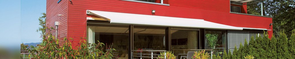 Een moderne woning met een rode gevel en een overdekte terrassituatie. Een moderne woning met een rode gevel en een overdekte terrassituatie.
