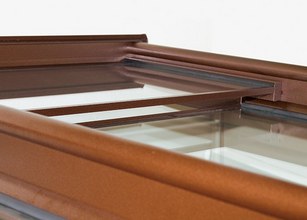 Detailopname van een bruine constructie met glazen elementen en een strakke vorm. 